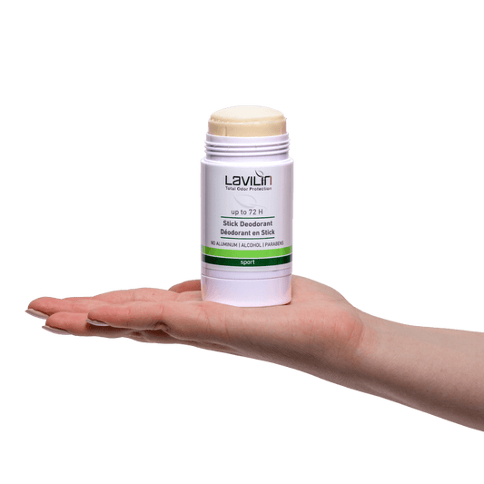 Stick Sport deodorant in a white container held in a hand, featuring a twist-up mechanism and green label.